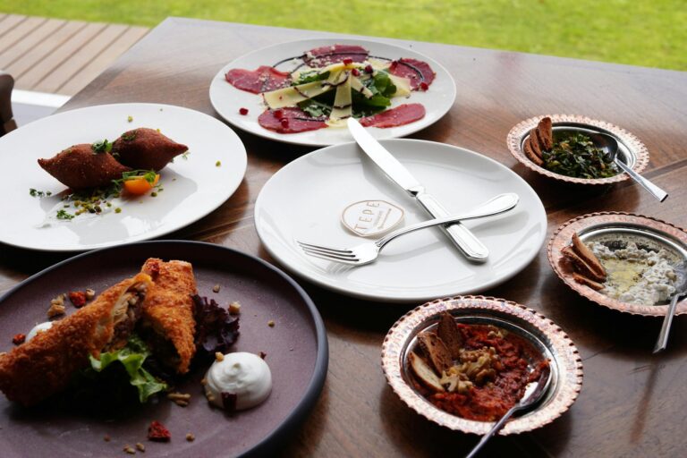 Assorted Turkish mezze dishes elegantly arranged on a wooden table, showcasing a blend of flavors and textures.